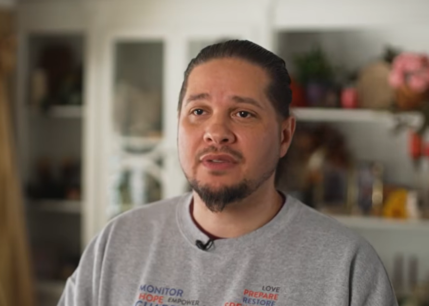 A man talking in a living room.