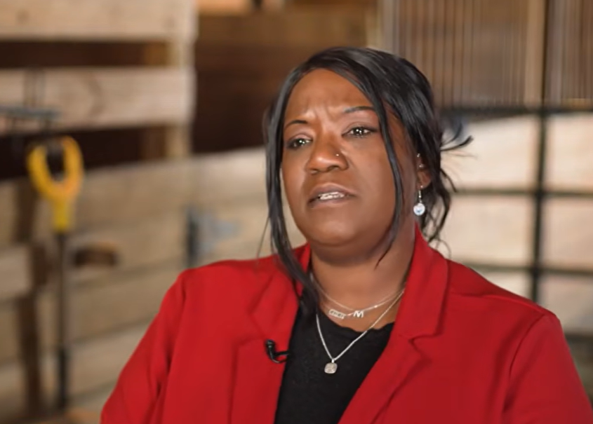 A woman talking in a barn.
